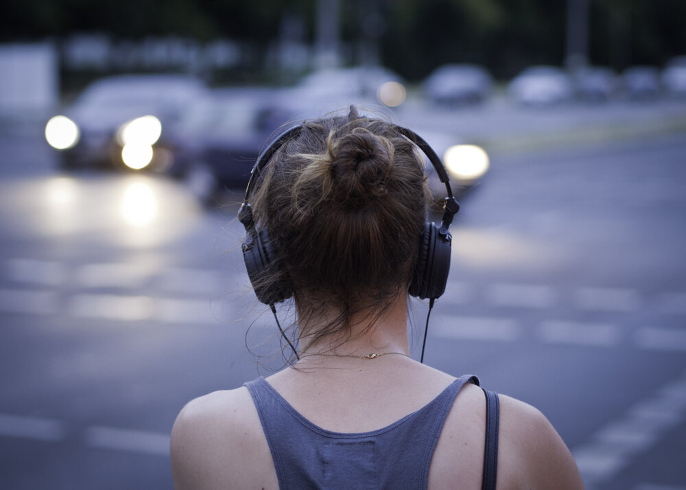 Woman Listening to podcast facing away from camera